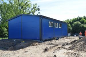Niebieski budynek stacji uzdatniania wody, wokół budynku plac budowy