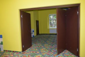 Duże drewniane drzwi, oddzielajace sale lekcyjne