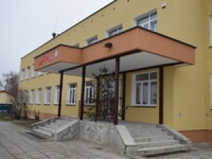 Weście główne do budynku szkoły z odnowioną elewacją w kolorze ciemnej żółci