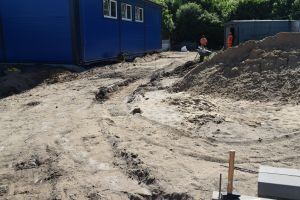 Utwardzony plac, wysypany piaskiem, przygotowany pod ułożenie kostki brukowej