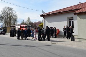 Grupa osób stojąca przed wyremontowanym budynkiem świetlicy wiejskiej