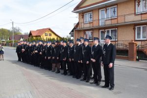 Grupa strażaków stojąca w rzędzie na ulicy