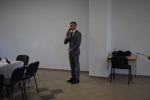 Mężczyzna w garniturze przemawia w dużej sali