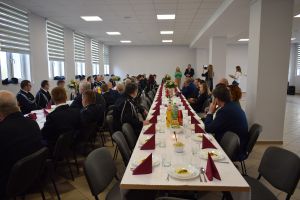 Ludzie siedzący za zastawionymi stołami w dużej sali