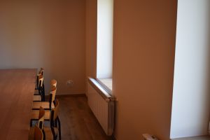Część sali, na której widać okno, krzesła i stoliki