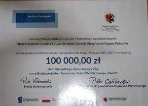 Plakat ukazujący kwotę dofinansowania na utworzenie klubu młodzieżowego