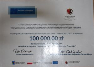 Plakat ukazujący kwotę dofinansowania na utworzenie klubu młodzieżowego