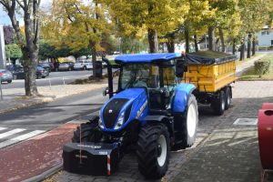 Niebieski ciągnik z żółtą przyczepą zakupiony na potrzeby PSZOK