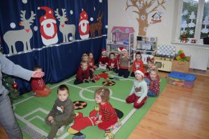 Mikołaj odwiedzający uczniów i przedszkolaków i częstujący ich słodyczami z czerwonego worka