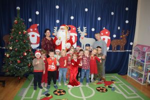 Mikołaj odwiedzający uczniów i przedszkolaków i częstujący ich słodyczami z czerwonego worka