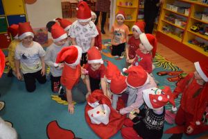 Mikołaj odwiedzający uczniów i przedszkolaków i częstujący ich słodyczami z czerwonego worka