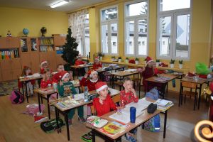 Mikołaj odwiedzający uczniów i przedszkolaków i częstujący ich słodyczami z czerwonego worka