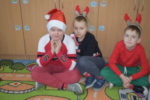 Mikołaj odwiedzający uczniów i przedszkolaków i częstujący ich słodyczami z czerwonego worka