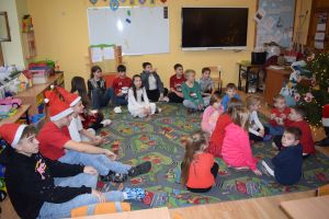 Mikołaj odwiedzający uczniów i przedszkolaków i częstujący ich słodyczami z czerwonego worka