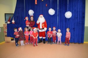 Mikołaj odwiedzający uczniów i przedszkolaków i częstujący ich słodyczami z czerwonego worka