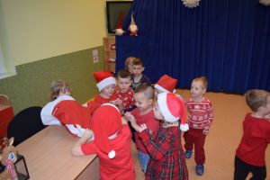 Mikołaj odwiedzający uczniów i przedszkolaków i częstujący ich słodyczami z czerwonego worka