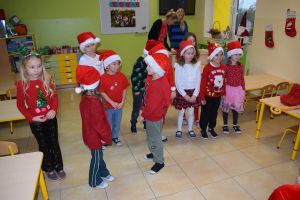 Mikołaj odwiedzający uczniów i przedszkolaków i częstujący ich słodyczami z czerwonego worka