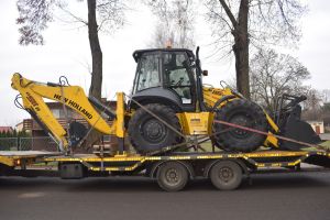 Żółta koparko-ładowarka na samochodzie dostawczym