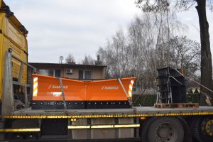 Żółta koparko-ładowarka na samochodzie dostawczym