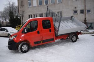 Czerwony samochód dostawczy w wywrotką na tle budynku