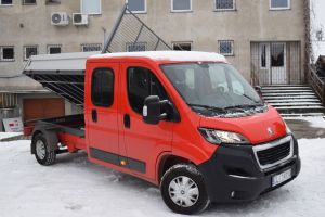 Czerwony samochód dostawczy w wywrotką na tle budynku