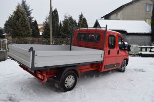 Czerwony samochód dostawczy w wywrotką na tle budynku