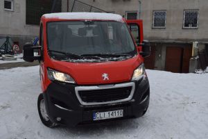 Czerwony samochód dostawczy w wywrotką na tle budynku