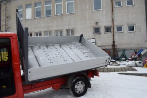 Czerwony samochód dostawczy w wywrotką na tle budynku