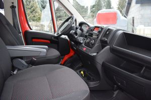 Czerwony samochód dostawczy w wywrotką na tle budynku