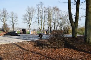 Betonowy plac w parku, na nim powstające elementy skateparku