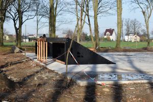 Betonowy plac w parku, na nim powstające elementy skateparku