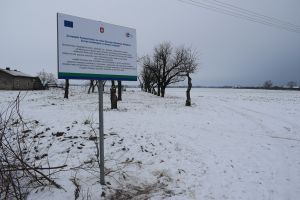 Teren w Glewie, gdzie ułożono kolejny odcinek wodociągów oraz na pierwszym planie tablica informujaca o inwestycji