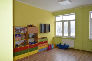 Sala lekcyjna w kolorze ścian zielono-żółtym wraz z wyposażeniem-ławki, krzesła, szafki